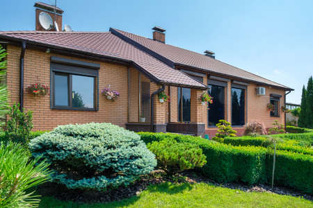 European style villa with and garden with nicely trimmed bushes in front of the house. Landscape design. High quality photoの写真素材