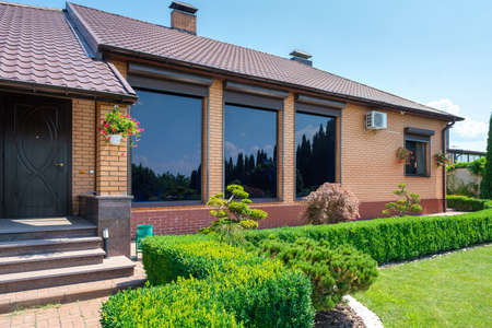 European style villa with and garden with nicely trimmed bushes in front of the house. Landscape design. High quality photoの写真素材