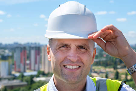 Portrait of smiling construction engineer in hardhat and with jacket on shoulders. High quality photoの写真素材