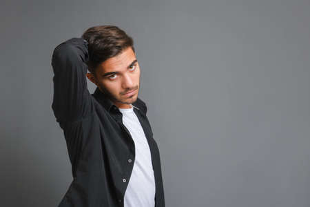Close-up portrait of handsome serious guy on gray background. High quality photo, copy spaceの写真素材