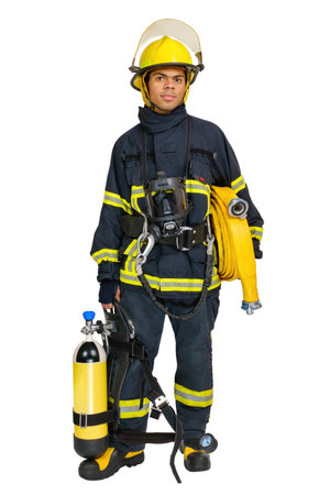 Full body young smiling African-American man in uniform of fireman with breathing air cylinder apparatus and full facepiece respirator and fire hose in hands, isolated on white backgroundの写真素材