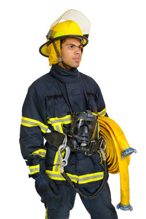 Young African American fireman in uniform and helmet holds fire hose in hands and looking away isolated on white background, vertical orientationの写真素材