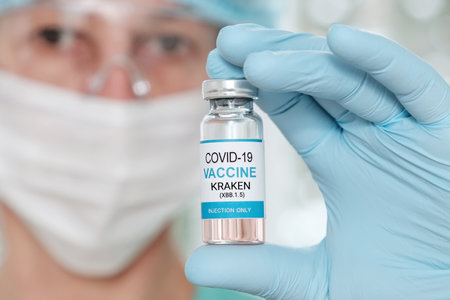 Closeup woman doctor hand holds vial with coronavirus Covid19 Kraken variant strain vaccine.の写真素材