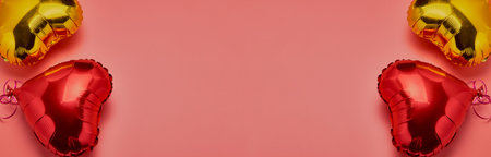 Air Balloons of heart shaped foil, red and gold, on a pink background. The concept of love,...