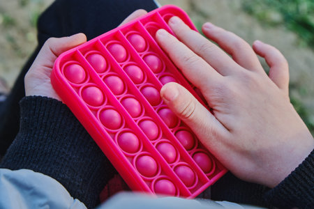 A new popular trend toy for stress relief in the hands of a child 7-9 years old.の写真素材