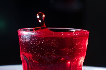 drops of red liquid in glass beakerの写真素材