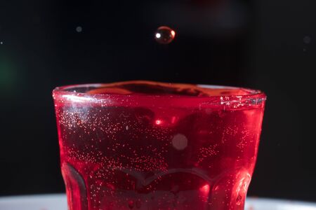 drops of red liquid in glass beakerの写真素材