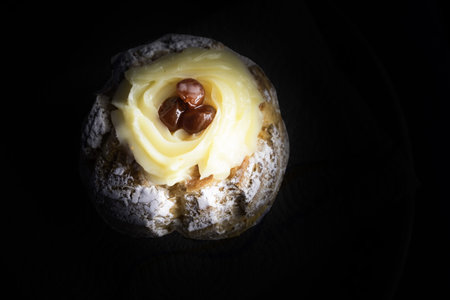Zeppole of Saint Joseph, Italian pastry with flour, sugar, eggs, oil, decorated with a sour cherry....