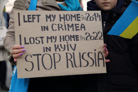 Protest against the war in Ukraine. Demonstrators with banners and flags of Ukraine and Russia.
