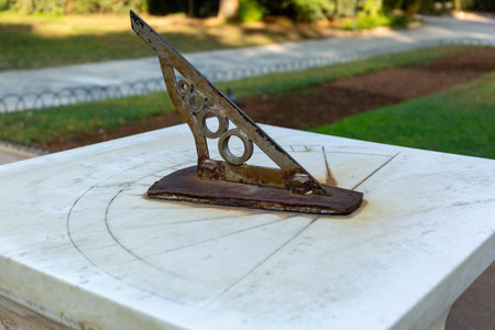 Old rusty sundial on a white marble table in the garden.の写真素材