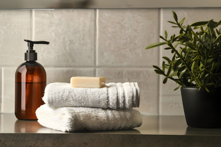 An illustration of a shampoo bottle next to towels in the bathroom. bathroom accessories. bottle of care product without insert label. modern designの素材