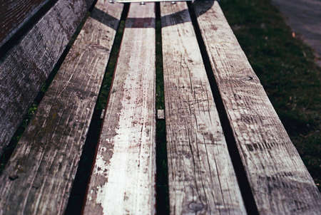 close-up of a park bench, old boards covered with cracks, almost black and whiteの写真素材