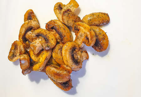 browned mushrooms, fried in oil, lie on a plate, sprinkled with dillの写真素材