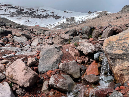 Mountain landscape with a stream of water and stones on the slopes Cimborazoの写真素材