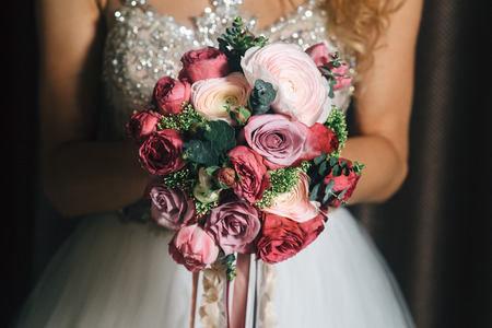 the girl holds a bridal bouquet in handの写真素材