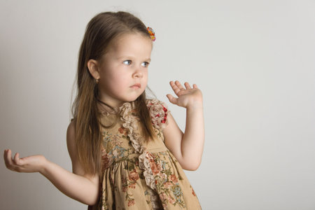 Little girl hands up, gray backgroundの写真素材