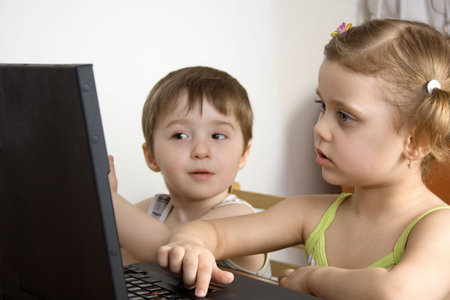 little girl and little boy working with a laptop