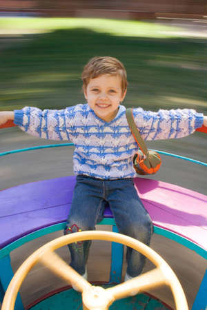 The happy little girl is turned on a roundaboutの写真素材