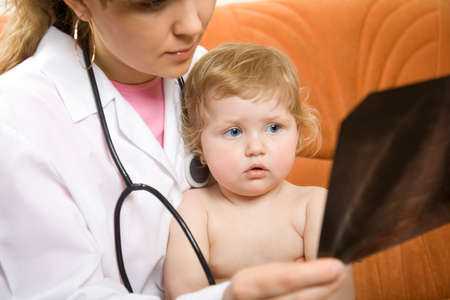 Doctor pediatrician and little child looking at an xrayの写真素材
