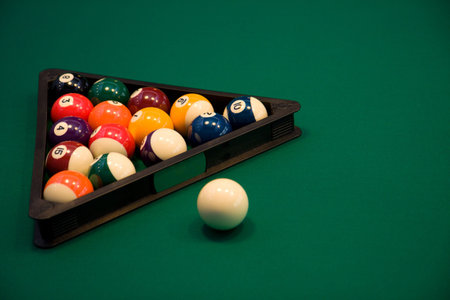 Color billiard balls on a green table in sport bar 