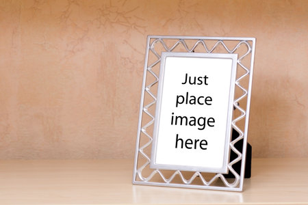 Metallic photo frame on a wooden shelfの写真素材