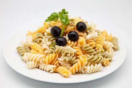 plate of macaroni cooked with black olives and parsleyの写真素材