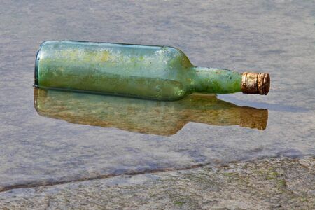 glass bottle floating on the shoreの写真素材