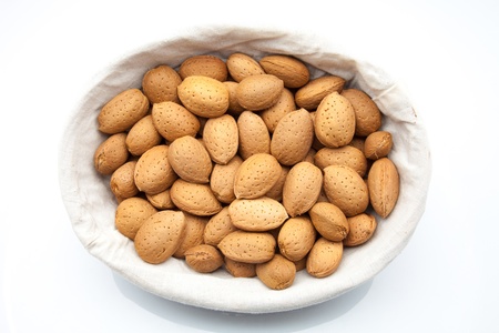 almonds in a basket on white fundの写真素材