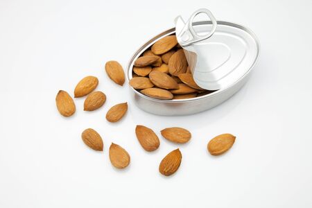almonds of a canister opened in white fundの写真素材