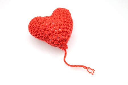 Red heart shape symbol made from wool isolated on white backgroundの写真素材
