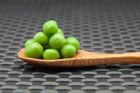 green peas on a wooden spoonの写真素材