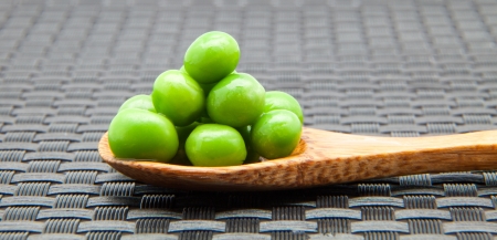 fresh peas in a wooden spoonの写真素材