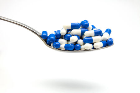 Blue capsules in silver spoonの写真素材