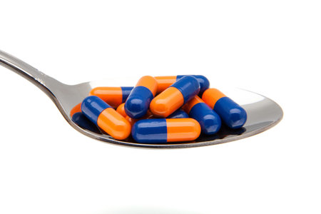 capsules in a spoon on a white background