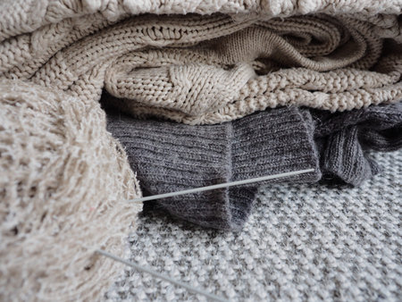 Knitted sweaters with knitting needles and wool