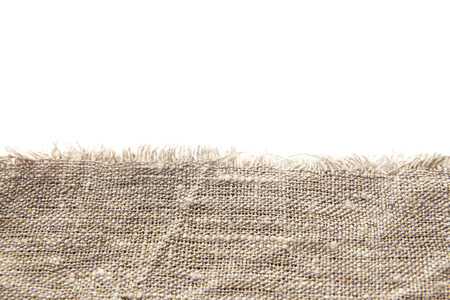 Background and texture of gray coarse linen fabric with close weaving and fringe along the edge on a white isolated background.の写真素材