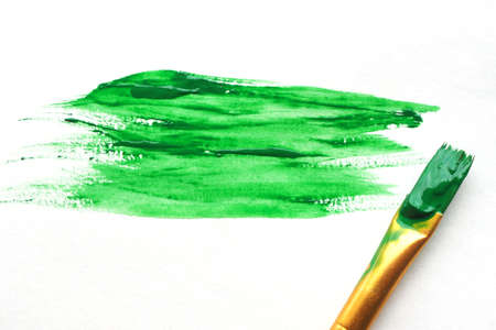 Smeared dark green acrylic paint and paint brush. Random strokes. Space for text.の写真素材