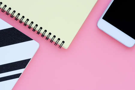 Minimalistic abstract geometric background. notepads and smartphone on a pink background. Space for text.の写真素材