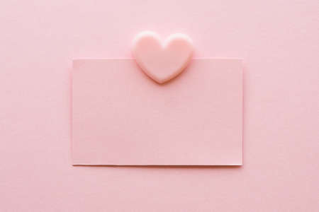 postcard pink rectangular sticker and pink clip in the form of a heart on a pink background. Monochrome minimalistic background. space for text.の写真素材