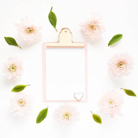 Mock up pink clipboard and pink chrysanthemum flowers in a circle. Space for text.