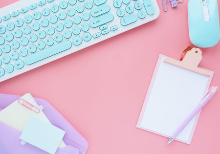 business and stationery accessories neatly laid out on a pink background. Flat layout, top view.