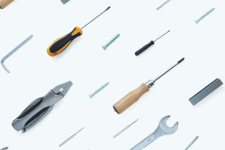 A pattern of tools: nippers, screwdrivers, keys, bolts, staples for a stapler, self-tapping screws, nut on a white background.の写真素材