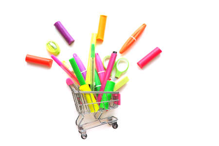 miniature grocery cart from the supermarket and stationery falling out of it, pens, scissors, Plasticine, felt-tip pens, eraser, sharpener. Isolate on a white background.の写真素材