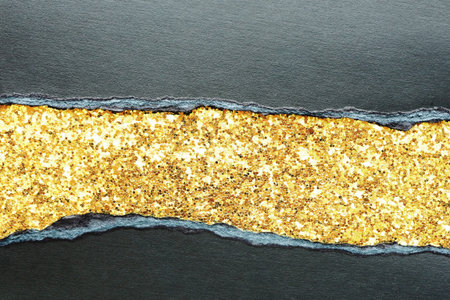 Abstract background and texture of torn black paper and shiny with gold glitter fabric. Black...