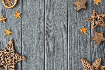 Stars of dried orange peels, made of wood and wicker on a gray wooden background.