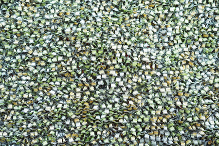 Background and texture of a knitted fabric in yellow-green color. Coarse knitting, ribbon yarn.