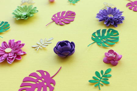 Pattern of paper leaves of the Monstera pink and green and small leaves of golden color and handmade...