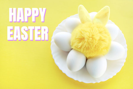postcard bright yellow toy bunny on a plate with white eggs on a yellow background and the...