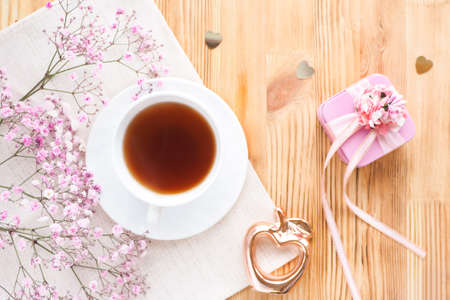 tea cup, gift box and flowers on a wooden background. lifestyle, top view.の写真素材