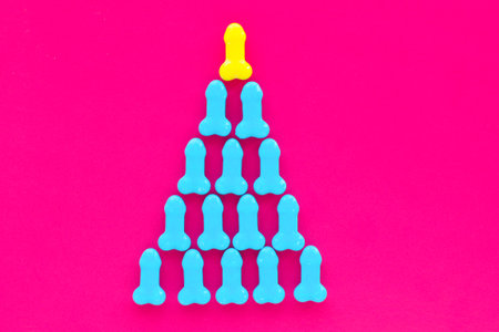 pyramid of candy on a pink background. yellow at the top and blue at the bottom. the concept of superiority, goal achievement, male superiority, patriarchy.の写真素材